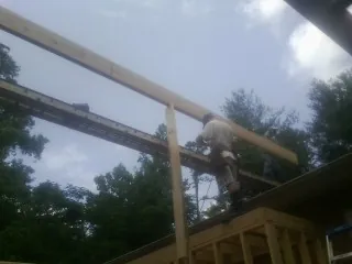 Carpenter setting a ridge beam over a new addition frame — Ice Dam Removal by Roofing Brothers in Maxwell
